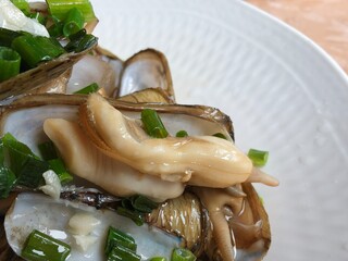 steamed razor clams with green onions and garlic on white plate © zhu difeng