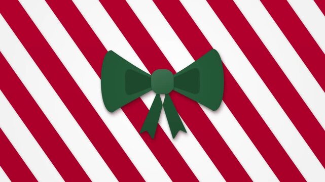 A green ribbon bow with trailing ends sits over red and white diagonal stripes. The stripes move behind the bow in a looping Christmas greeting card design