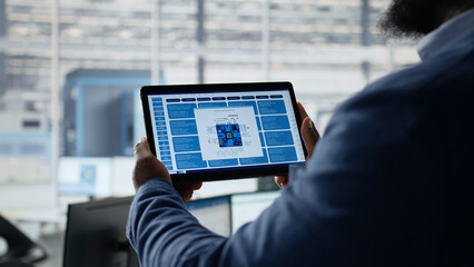 Microchip, tablet and engineer as professional examines detailed integrated circuit design on handheld screen. Semiconductor research, development and analysis guide hardware workflow in office. © DC Studio