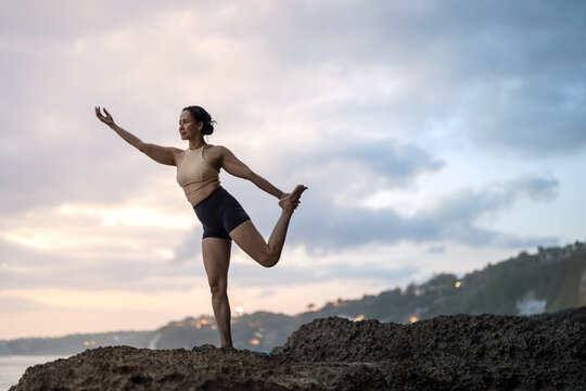 Asian woman enjoying a luxury yoga retreat and wellness getaway on tropical coast