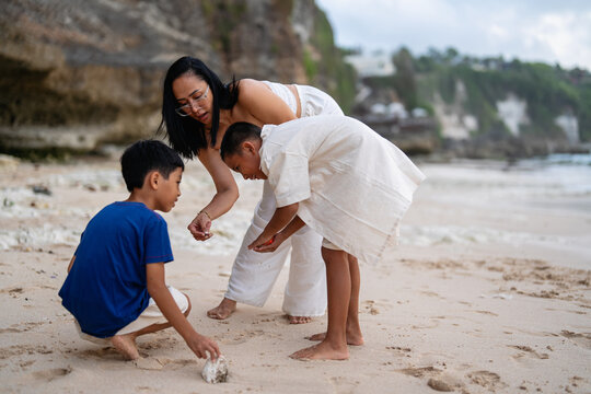 Asian family enjoying a summer vacation and playing together on a tropical beach