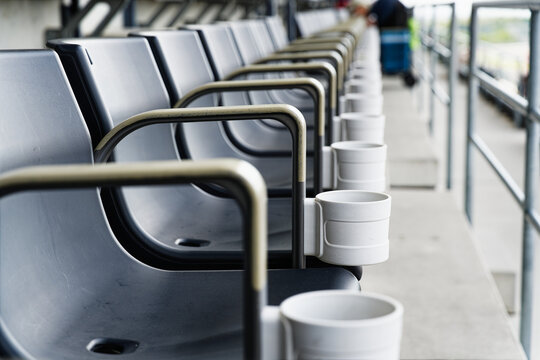 Row of Seats with White Cup Holders and Worn Armrests