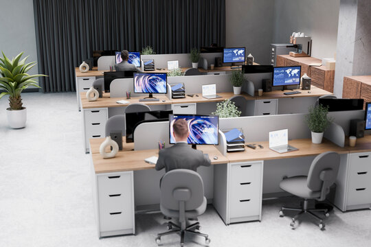 Front view of busy corporate office with employees at desks and collaborative workspace
