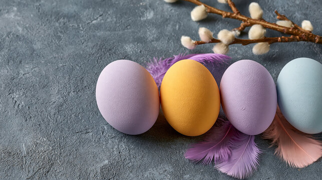 Four painted easter eggs decorated with pussy willow branches on a grey background
