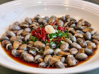 White plate filled with marinated mud snail appetizer dish © zhu difeng