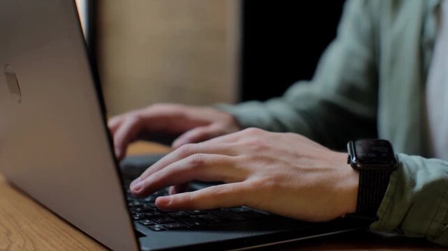 Man Hands Typing on Laptop Keyboard in Coffee Shop Close Up
