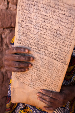 Hands holding an old wooden board covered with Arabic script, Sahel Region, Bani, Burkina Faso