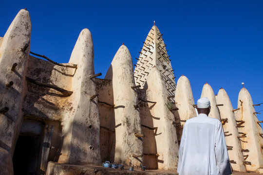 Man in white robe and skullcap walking toward the Grand Mosque, Hauts-Bassins Region, Bobo Dioulasso, Burkina Faso