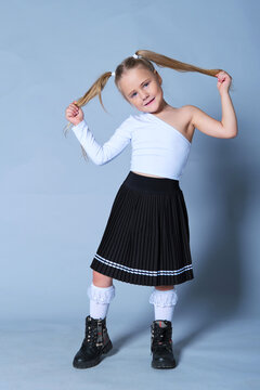 Girl with pigtails holding her pigtails and tilting her head