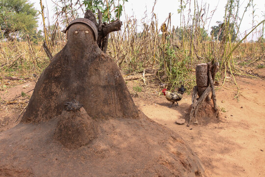 Lobi tribe fetish with cowrie shell eyes and a rooster in a dry field, Sud-Ouest Region, Gaoua, Burkina Faso