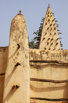 Mud towers and minaret of the grand mosque with wooden beams under blue sky, Hauts-Bassins Region, Bobo Dioulasso, Burkina Faso