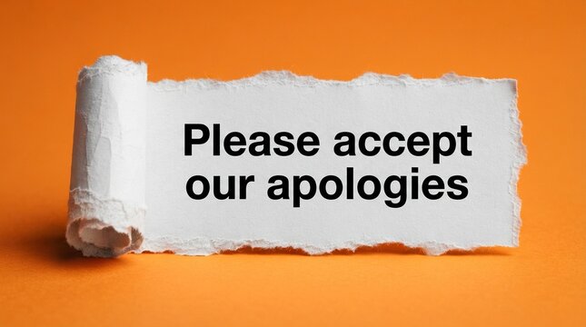 A white piece of rolled paper with the phrase please accept our apologies in black text on an orange background.