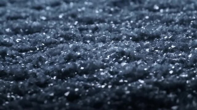 Closeup of dark blue crystalline granules glittering on a textured surface, shallow depth of field, slight shifting light