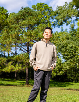 Outdoor portrait of friendly middle age asian male, relaxed casual outfit on sunny day