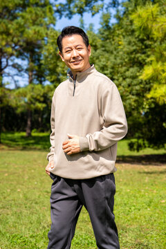 Outdoor portrait of friendly middle age asian male, relaxed casual outfit on sunny day