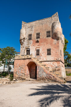 The historic Markellos Tower stands under a clear blue sky in Aegina Town, showcasing Venetian watchtower architecture and weather-worn stone masonry on Aegina Island, Greece