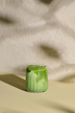 Refreshing Green Matcha Latte Served in Clear Glass on Beige Surface