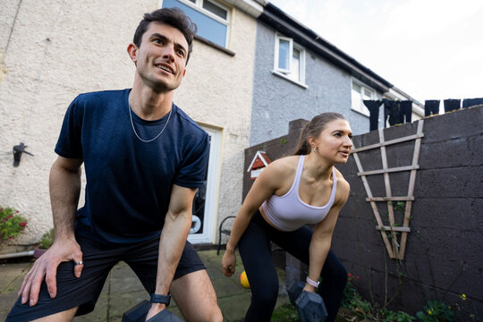 Couple exercises together in backyard during evening workout