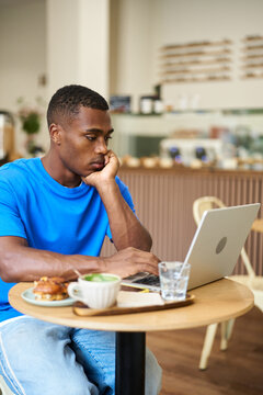 Person working remotely on laptop in cafe