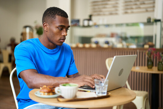 Person working remotely in a cafe using laptop