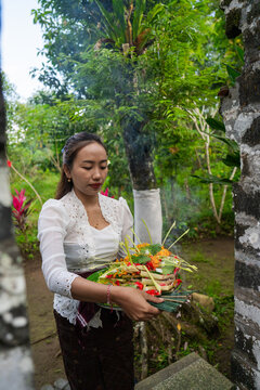 Woman Offers Prayer Basket in a Garden Setting