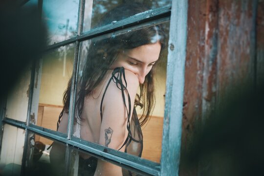 Pensive Woman Portrait Through Window