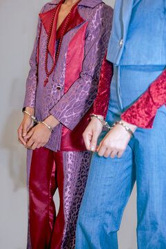 Two women connected by handcuffs and chains, dominance and submission