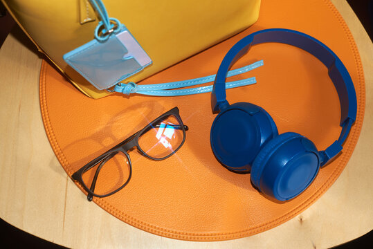 Glasses, wallet and bag placed on a orange placemat