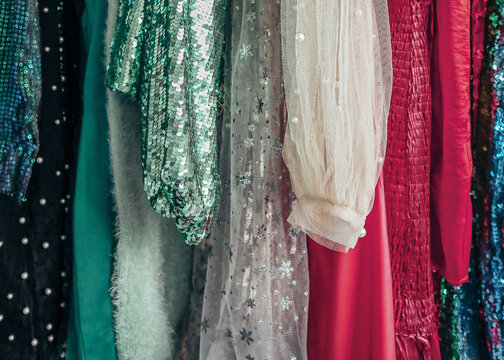 Sparkly holiday party dresses hanging on clothing rack