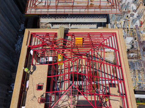 Aerial View Of Red Steel Roof Truss Framing And OSB Panels