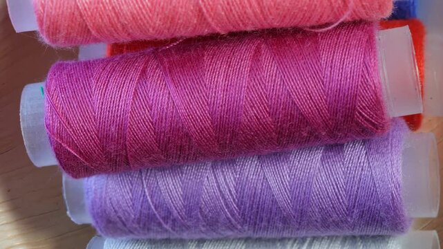 spools of colored thread stacked, sewing tools