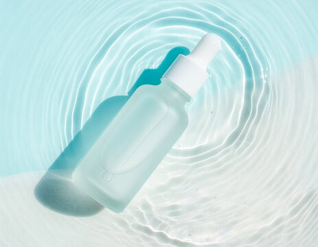 Frosted skincare dropper bottle mockup in shallow turquoise water with ripples
