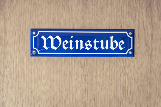 "Wine tavern" Weinstube in german Gothic font on Wooden door 
