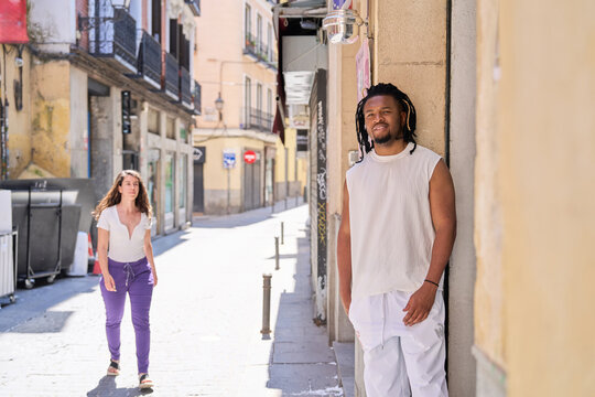 Diverse couple walking city street on sunny day