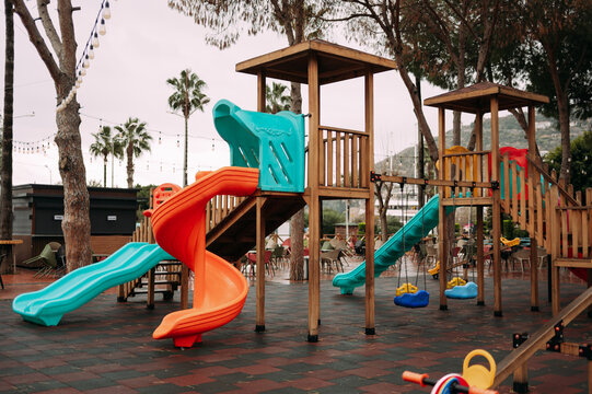 Colorful outdoor playground with slides and swings in a landscaped recreational area