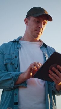 Farm worker analyzes tablet data among ripe wheat field crops