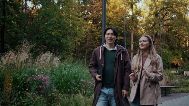 Couple walks together through peaceful autumn park pathway