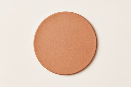 Blank round cardboard beer coaster with a fibrous pulp texture on a light background, a brown mockup template for pub branding and copy space