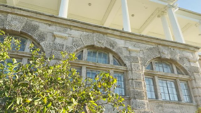 Tracking shot of the Cameron Gallery in Catherine Park, Pushkin, Saint Petersburg. Smooth sideways camera movement passes the stone facade, evoking peace, joy, and serenity.