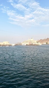 Muttrah Corniche in Muscat, Oman, featuring waterfront views, traditional architecture, harbor scenery, and coastal mountains. Muscat, Oman - August 03, 2026