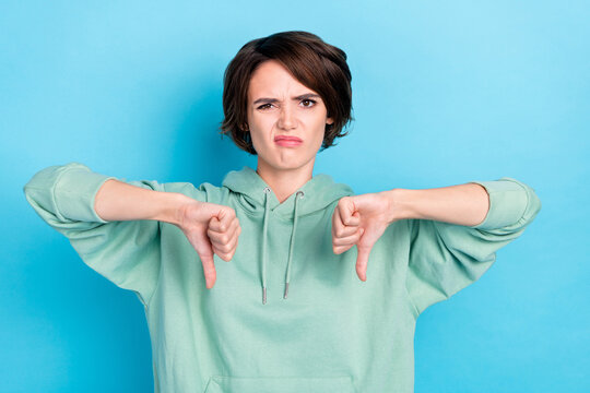 Photo of sad young bob hairdo lady thumb down wear green hoodie isolated on blue color background