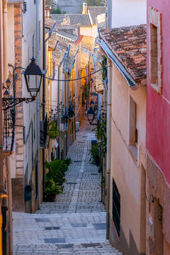 A picturesque treet of the historic centre of Biar, Alicante, Spain, with its colourful fa&ccedil;ades