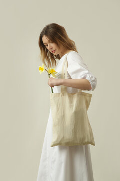 Female Fashion Model Wearing a Classic White Cotton Midi Dress with Puff Sleeves and Open Back, Casual and Comfortable Yet Stylish Summer Outfit