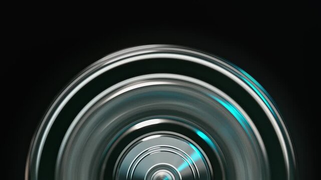 Close-up of metallic rings spinning in a dark environment, creating dynamic motion and chrome textures for futuristic visual projects.