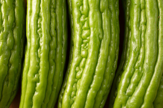 A top down view of a row of Chinese bitter melon, as a background.