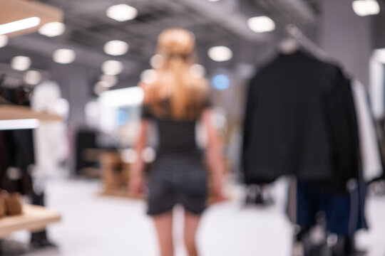 Woman browsing clothes inside a brightly lit retail store