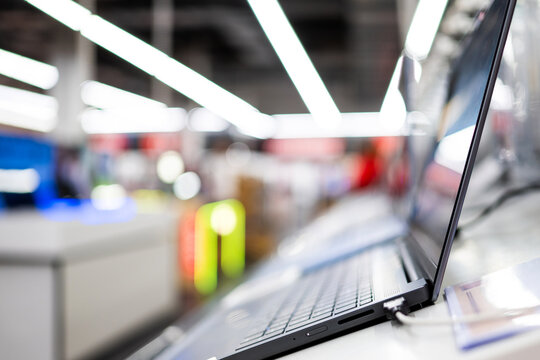 Modern laptop display on shelf in bright electronics store