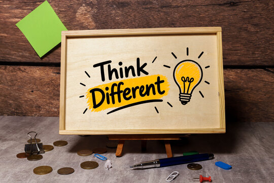 Think Different Creative Thinking and Innovation Mindset Concept with Light Bulb on Wooden Board.