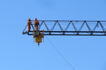 Industrial construction engineers working at height on a tower crane boom © Charles R