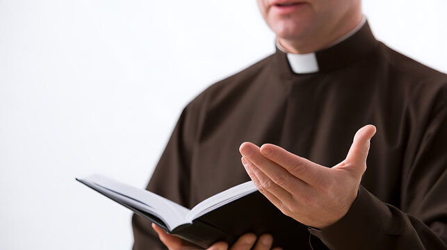 A clergyman holds an open holy book in hand while preach and share faith with devotion, wearing clerical collar shirt in studio background